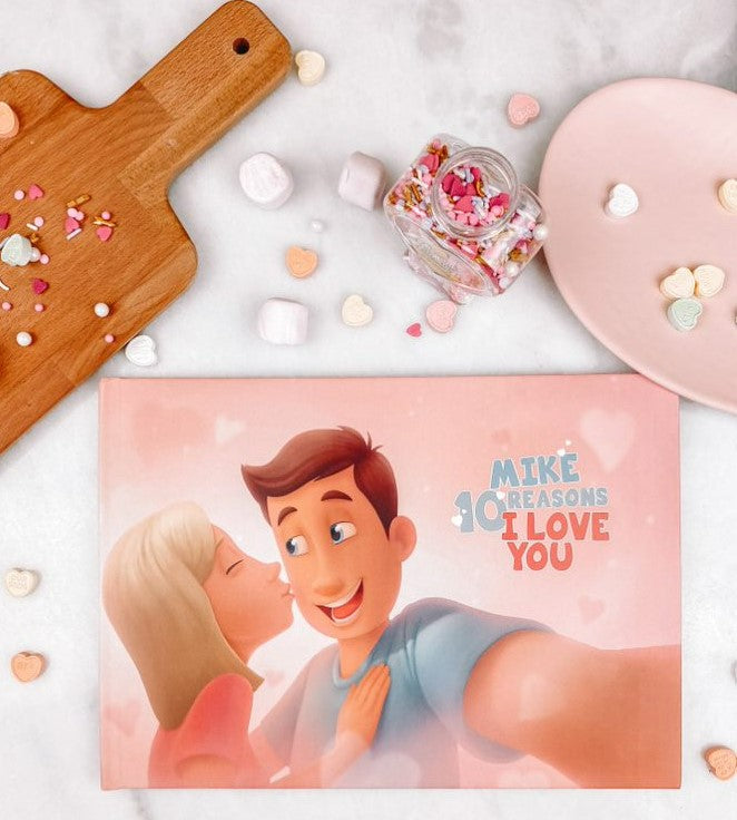 A Hooray Heroes personalized love book for couples, a cutting board and some Valentine's Day sweets.