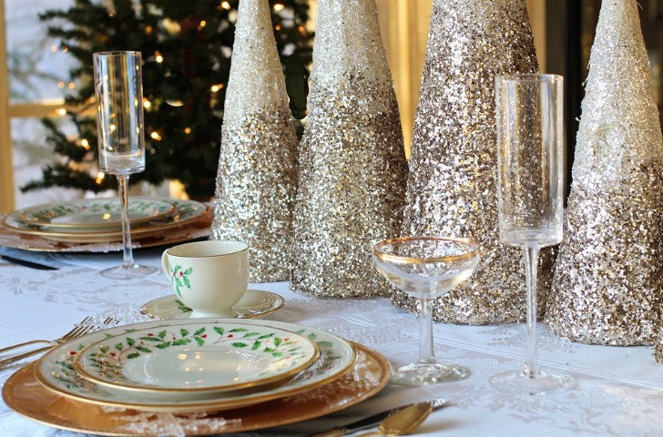 A table set for Christmas dinner with festive decorations and tableware.