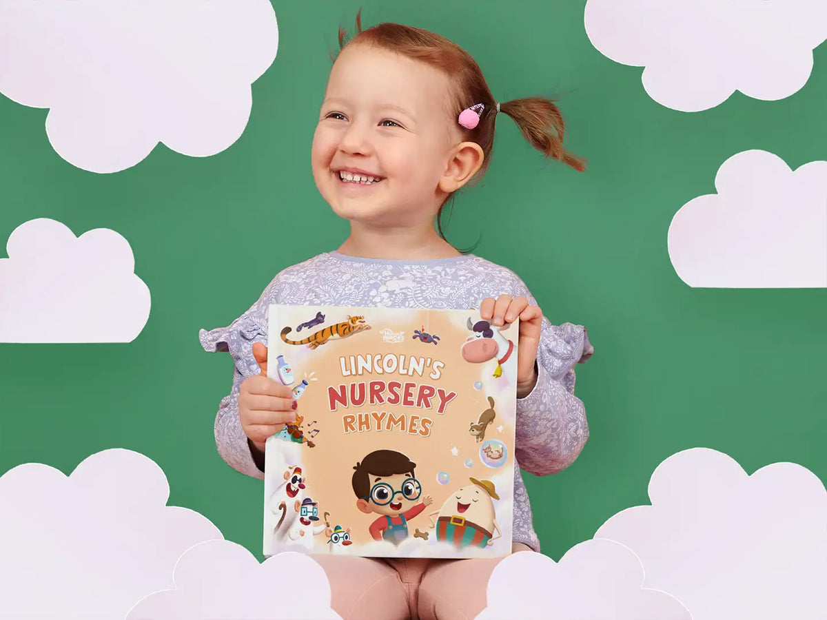 Little girl is smiling while holding this awesome gift for her baby brother, Lincoln's nursery rhymes by Hooray Heroes.