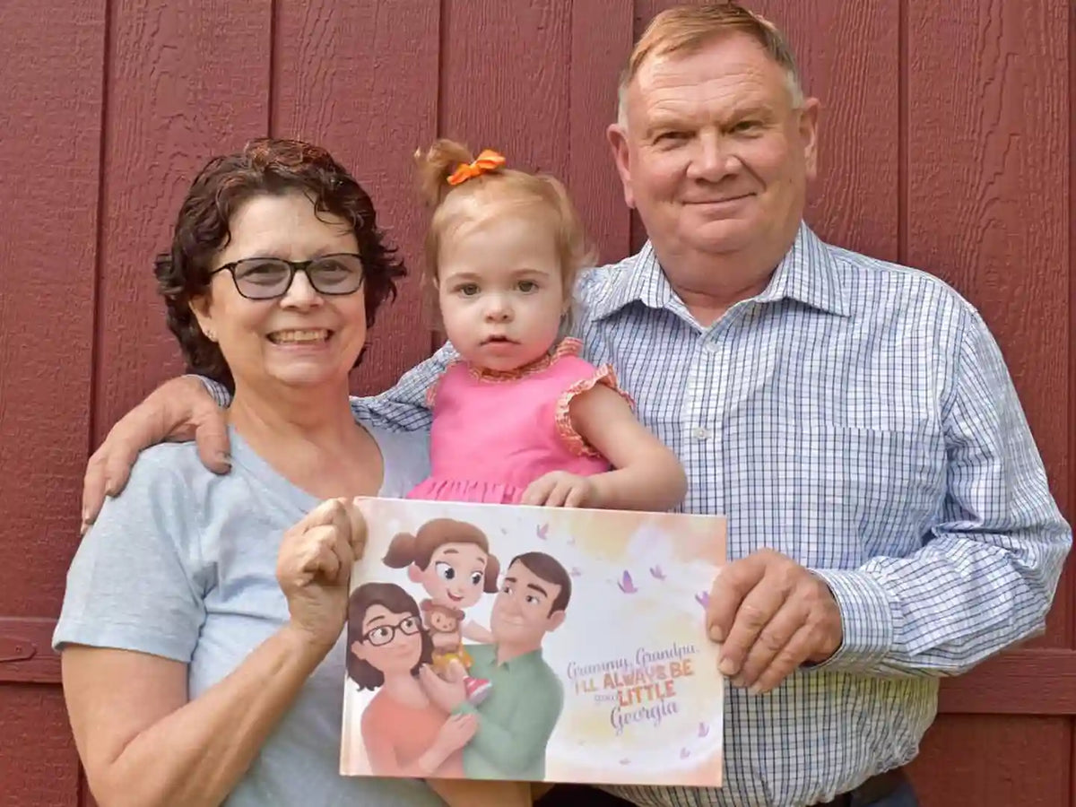 Grandparents and a little girl holding a book from Hooray Heroes dedicated to grandparents.