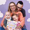 Family holding a personalized book for their new baby which they got as a present at birth.