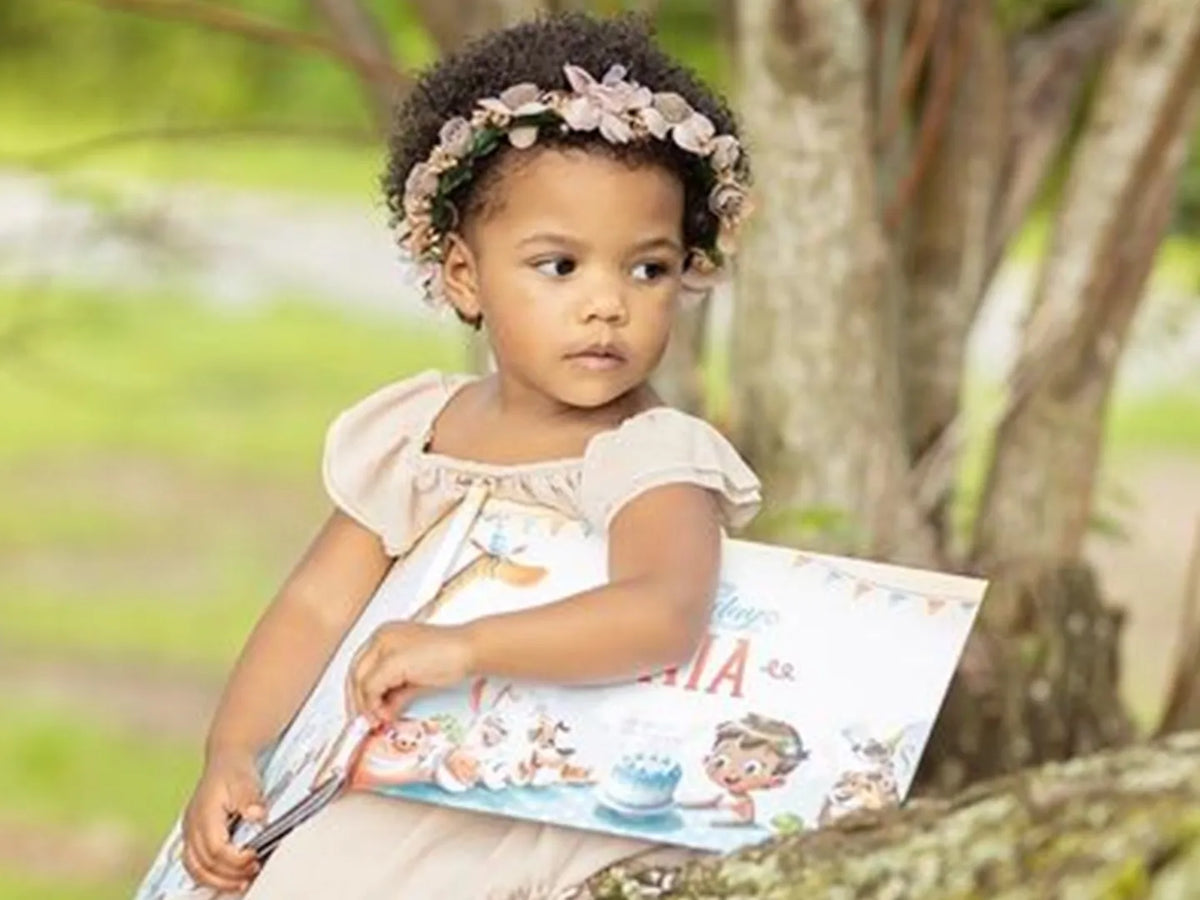 Three year old girl is holding her custom birthday book she got for her third birthday.