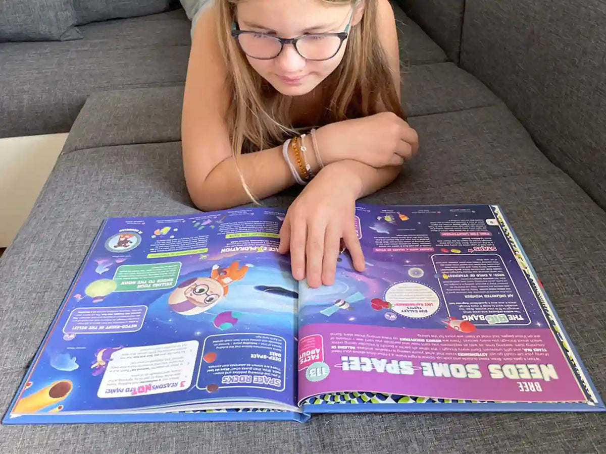 A girl is learning about space from her new personalized encyclopedia from Hooray Heroes .