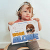 River is holding his personalized book River is home alone and looking forward of mischievous things.