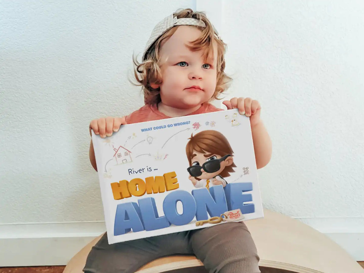 River is holding his personalized book River is home alone and looking forward of mischievous things.