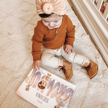 A little girl admires the cover of her very own custom growing up book starring her and daddy.