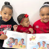 Three kids show their favorite picture from their one-of-a-kind DIY gift, a custom book about their adventures. 