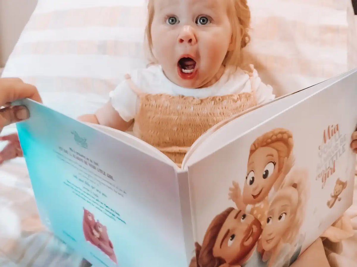 A girl looking at a personalized book for parents and their child.