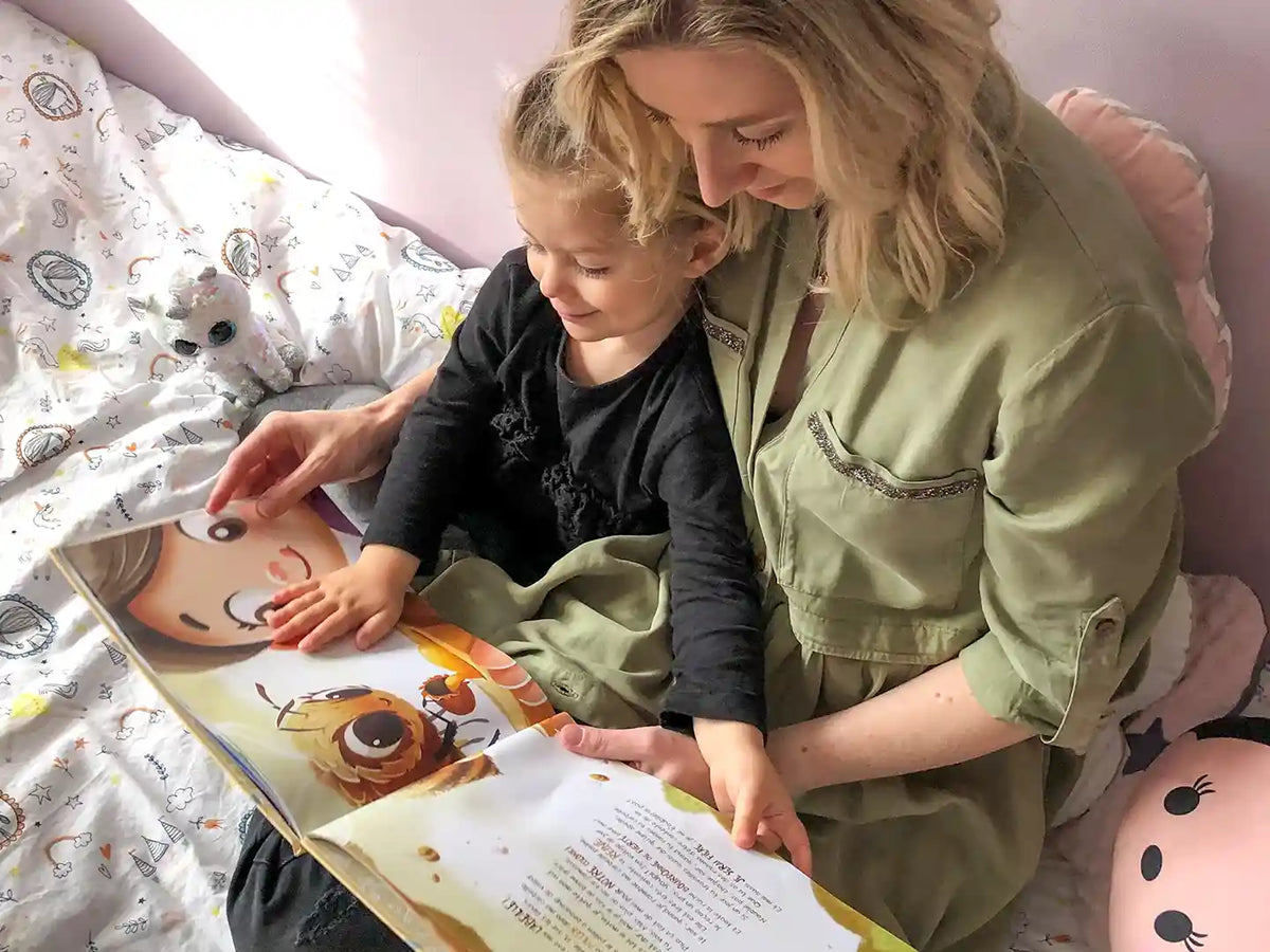 A mom and her four-year-old reading her personalized birthday book from Hooray Heroes.
