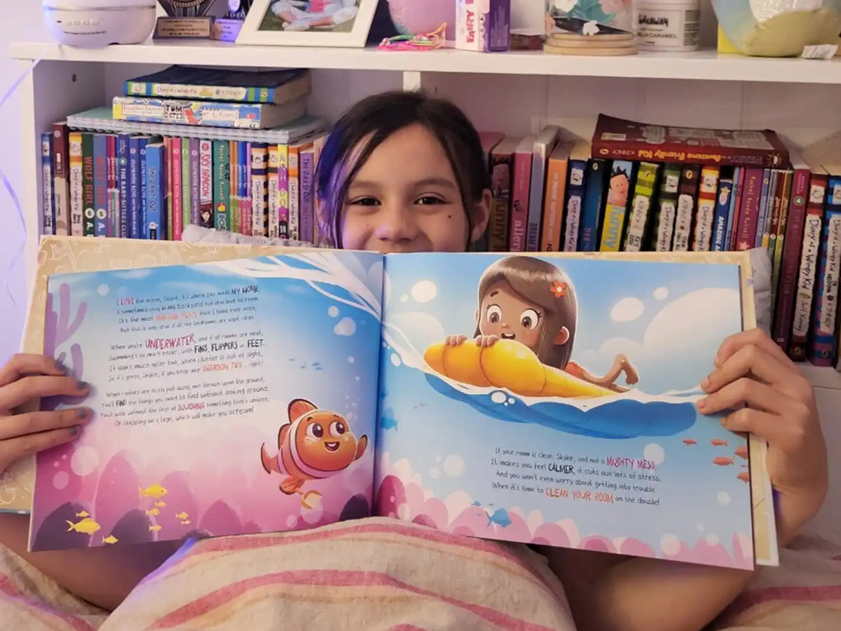 A seven-year-old girl is holding her personalized birthday book.