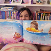 A nine-year-old girl is holding her personalized birthday book.
