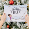 A woman is holding a personalized Christmas book, which is the best gift for kids for Christmas.