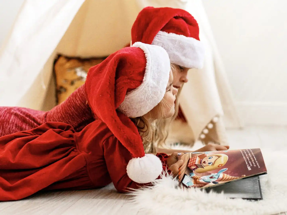 Two girls enjoying their personalized Christmas book.