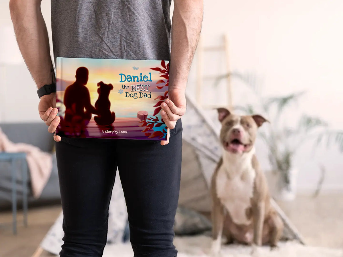 Personalized hardcover book 'Daniel the Best Dog Dad' held by owner, with his dog in the background — the perfect Father's Day surprise for dog dads.