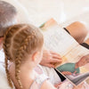 A grandpa and his granddaughter reading their personalized book starring them as the characters.