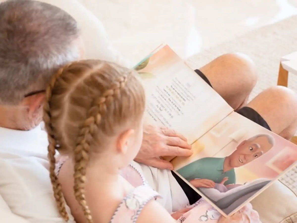 A grandpa and his granddaughter reading their personalized book starring them as the characters.