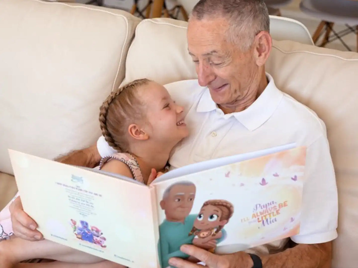 A grandpa and his granddaughter with their personalized book from Hooray Heroes.