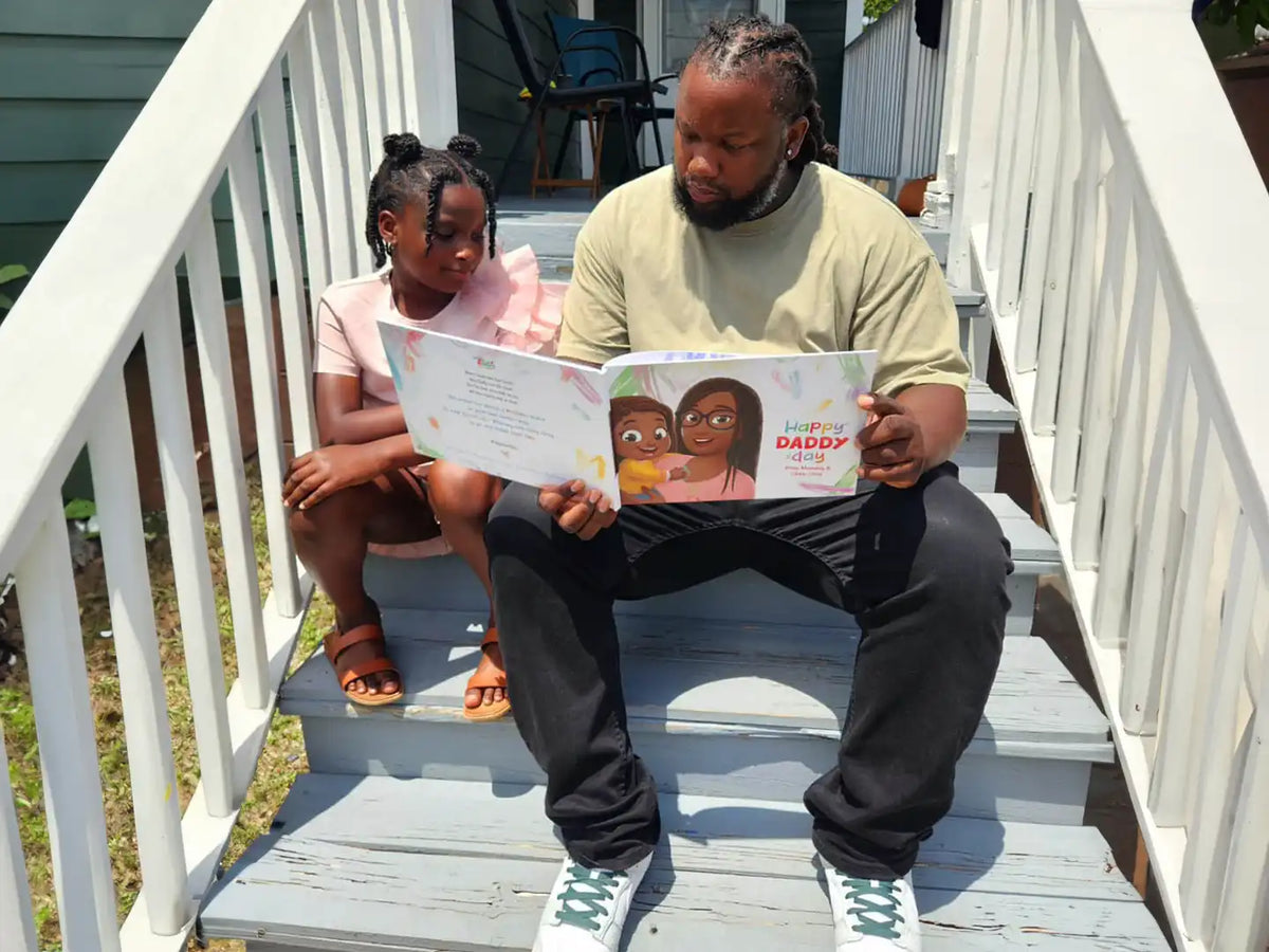 Girl and dad reading a personalized book which is a perfect gift for Father´s Day.