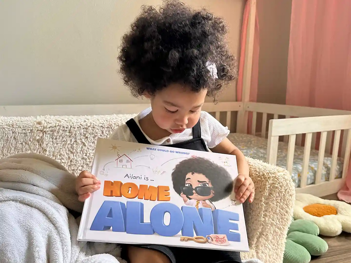 A little girl is looking at her new personalized home alone book.