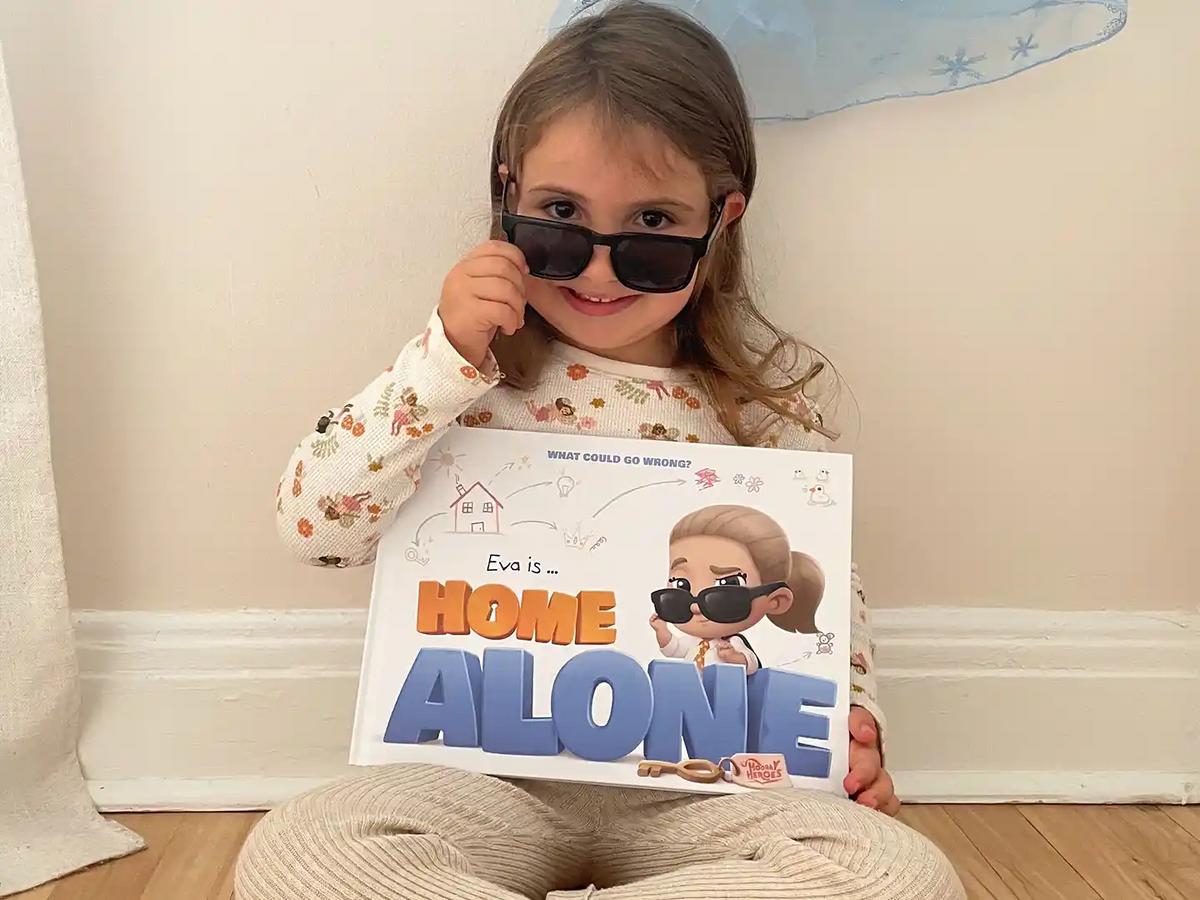 A smiling girl is posing with her new personalized Home Alone book from Hooray Heroes.