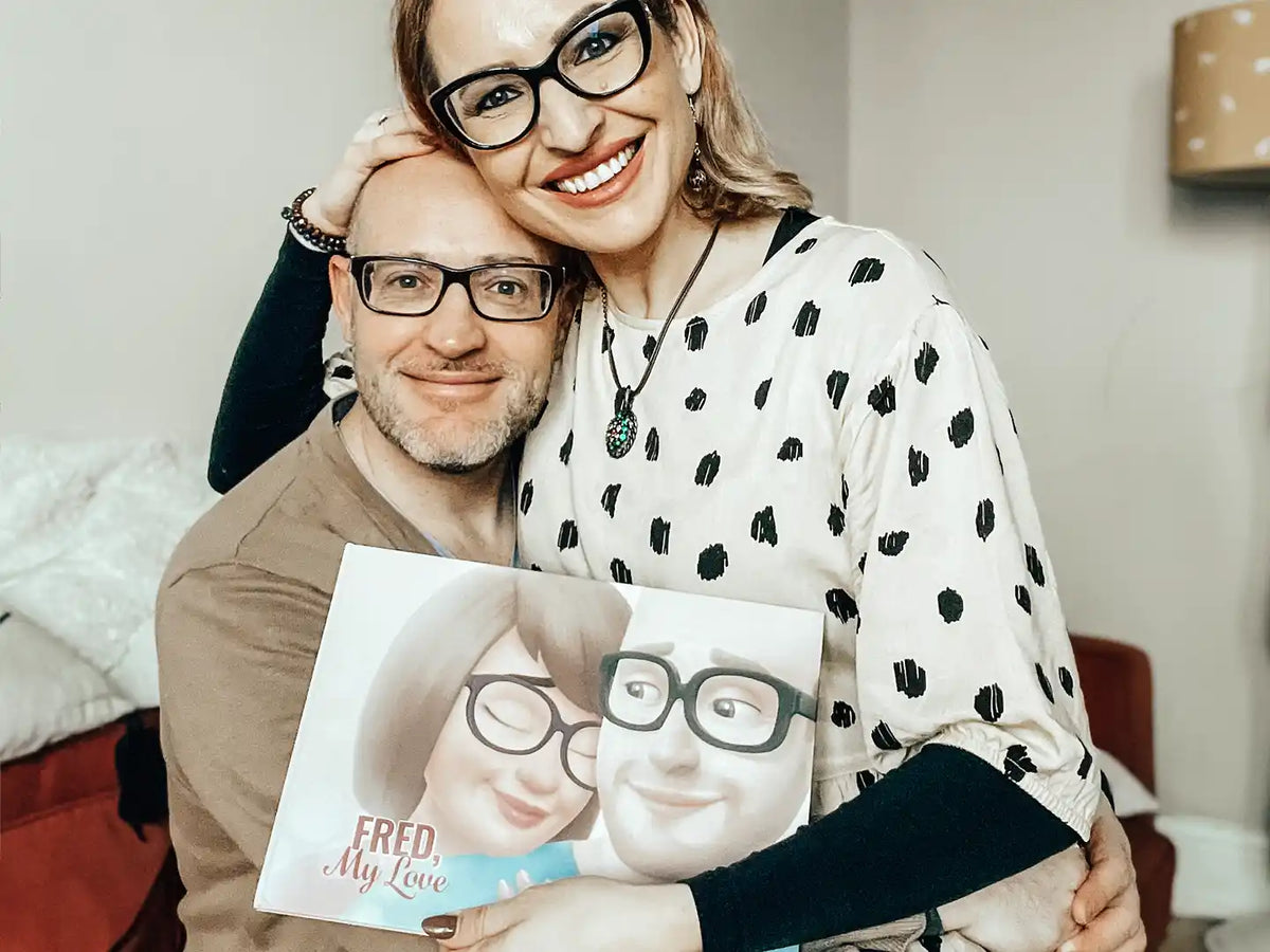 A smiling couple holding their personalized book for couples.
