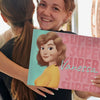 A smiling girl with her new personalized book which was a gift from her friend.