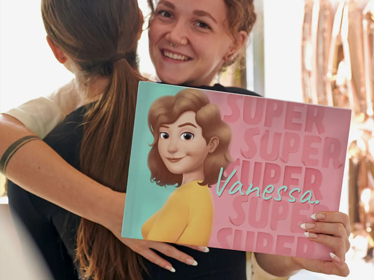 A smiling girl with her new personalized book which was a gift from her friend.