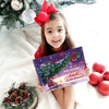 Girl holding a personalized “First Christmas 2025” book with her name on the cover.