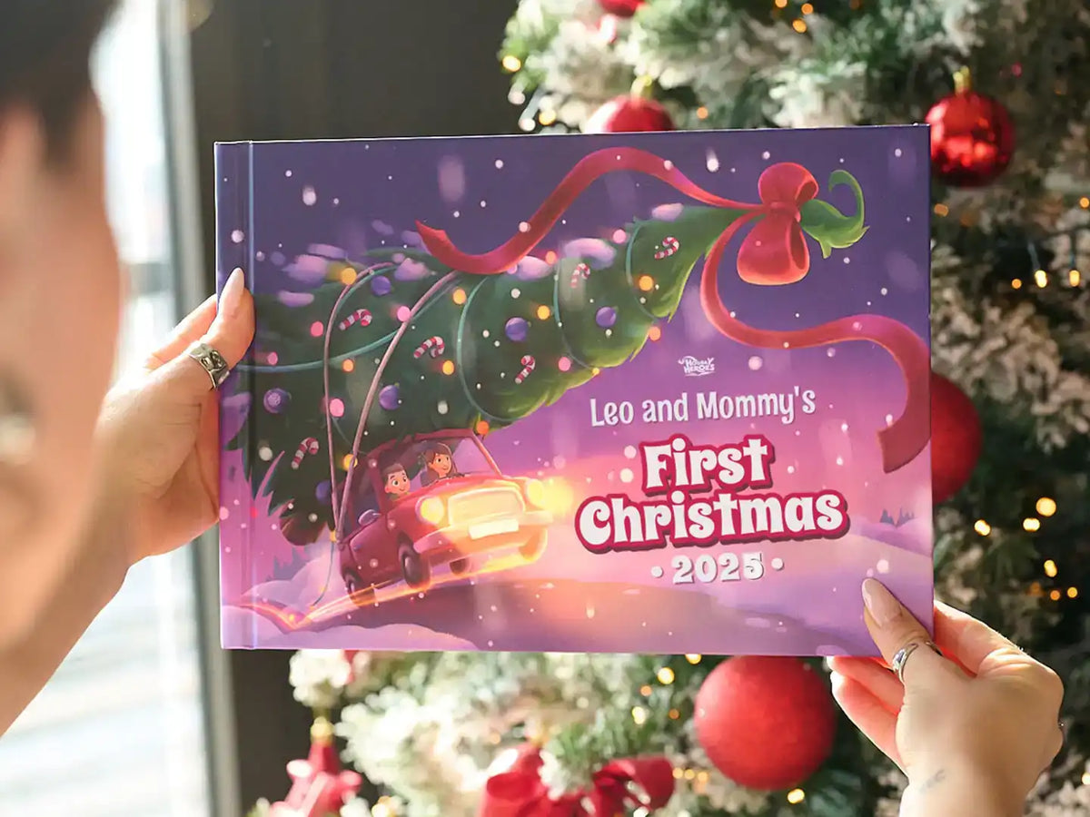 Person holding a personalized Christmas book titled “Leo and Mommy’s First Christmas 2025” in front of a decorated tree.