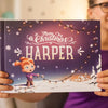 A woman is holding a personalized Christmas book, which is the best gift for kids for Christmas.